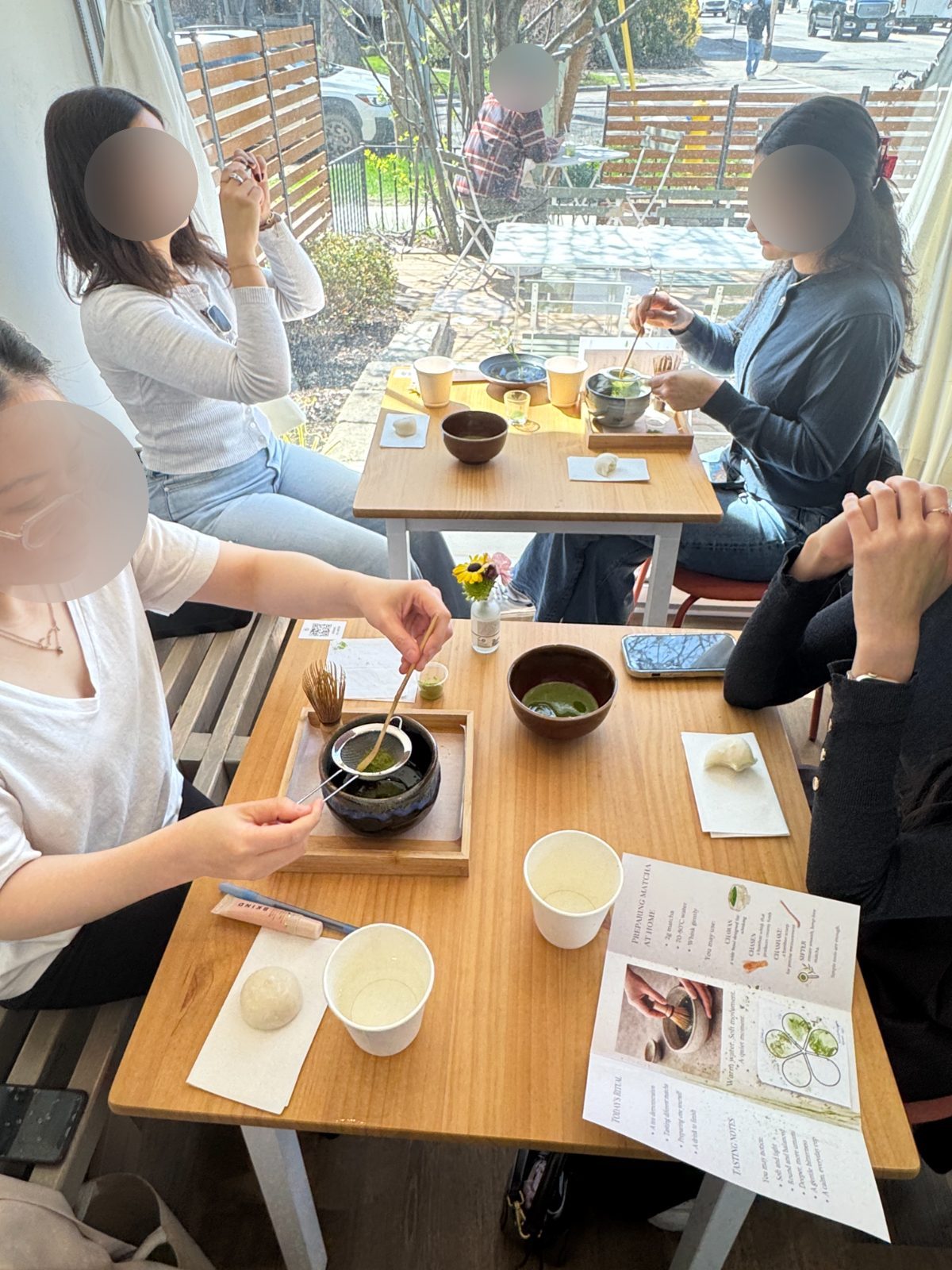 Guests sifting and whisking matcha at tables during a Gleam & Sip tea ceremony at the Annex, Toronto