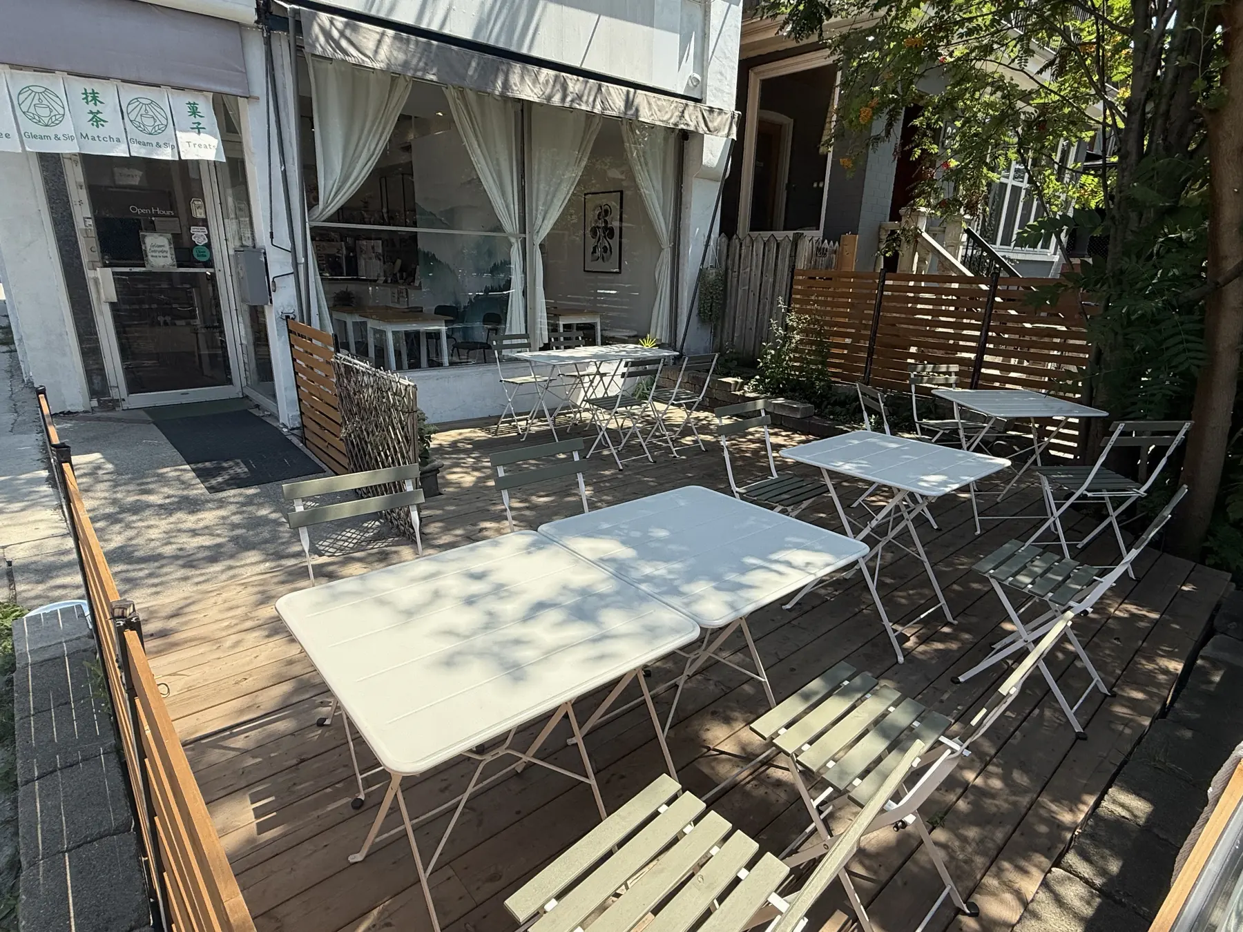 The full Gleam & Sip patio with outdoor tables beside the storefront